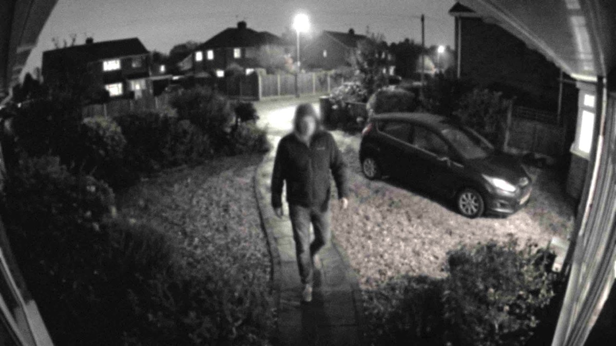 Simulated footage from an older CCTV camera: grainy black and white at night